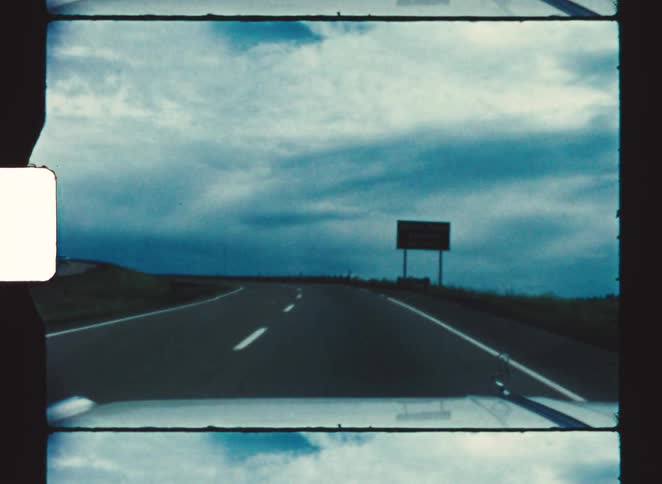 A road sign on the side of the road during a countryside road trip at midday
