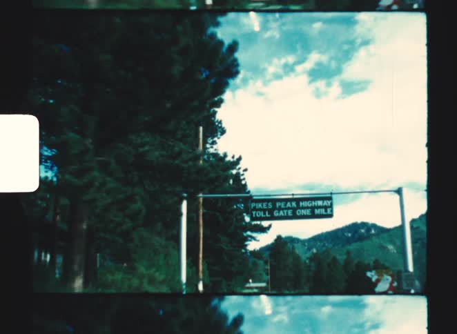 pikes peak highway toll gate one mile A road sign across the road during a countryside road trip at midday