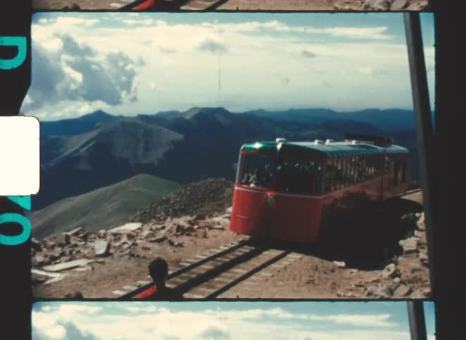 The passenger train travels on the mountain tracks