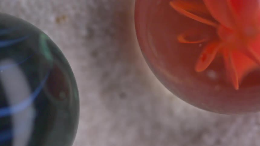 Two small glass spheres with red and blue colors inside