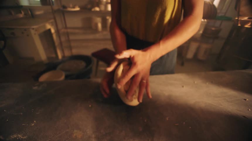 Woman kneads dough while working in the kitchen