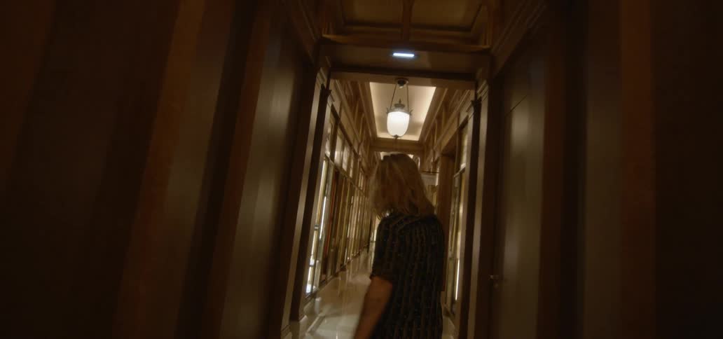A man walking down a long hallway