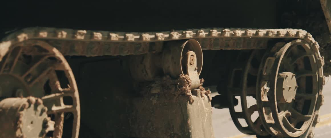 Armored vehicle track covered in mud after movement over rough terrain