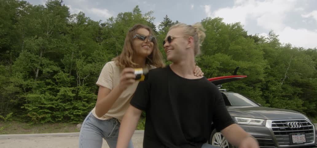 A man and woman outside kissing and taking pictures