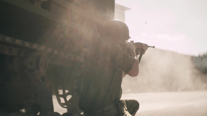 Military soldier next to a tank shooting his gun as smoke fills the air