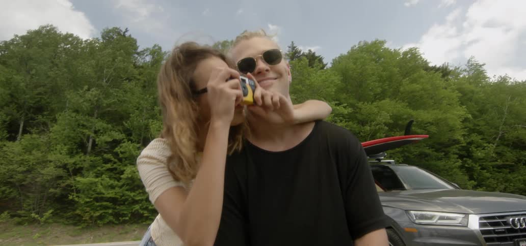 A man and a woman outside on a cloudy day taking a picture