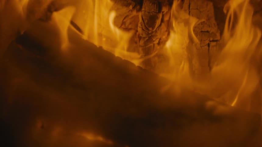 A view of a fire burning outdoors at night