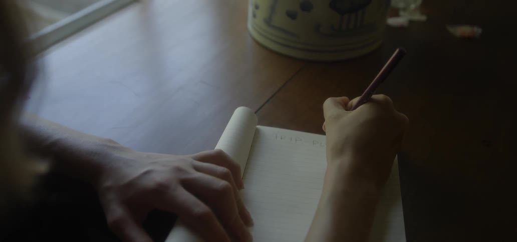 A woman writes in a notebook