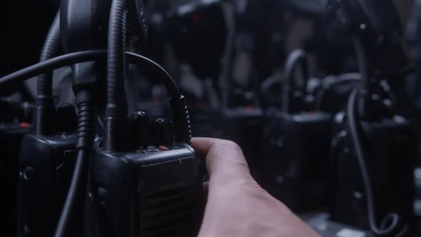 The person picks up a walkie talkie
