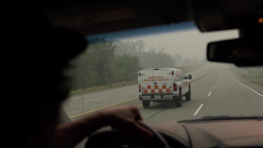 A penticton search rescue truck is followed down a foggy highway viewed from the trailing vehicles interior