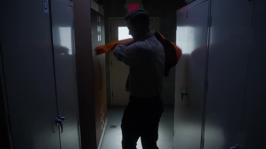 The man takes his coat and bag from the locker and leaves