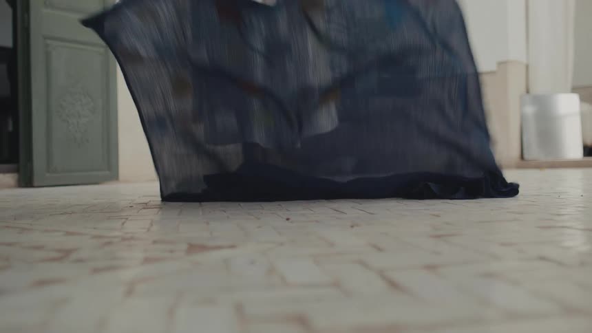 The woman drops the blue sheet