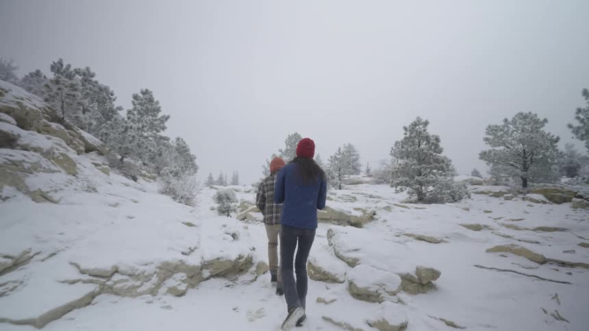 A couple people hiking through a snowy area