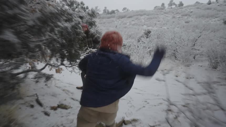 Two people playing at throwing snowballs at each other