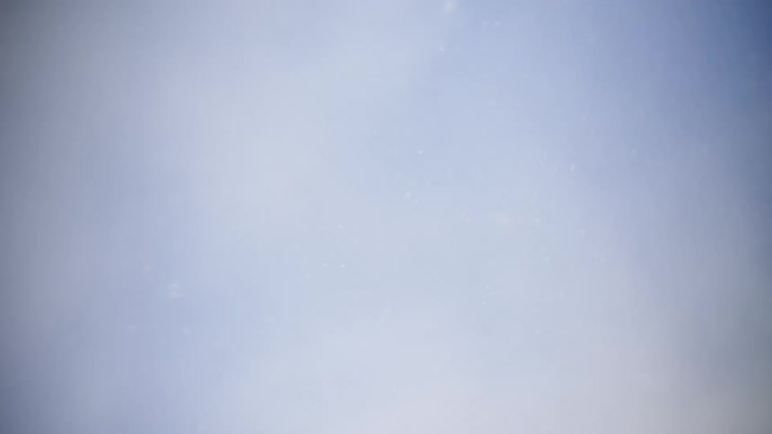 Snow flakes fall from a cloudy winter sky