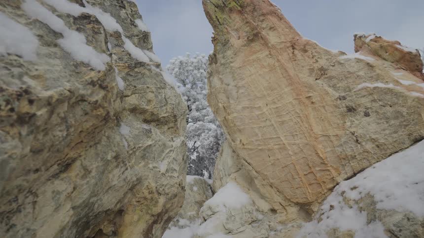 Snowcovered rock formations viewed from below under a clear sky