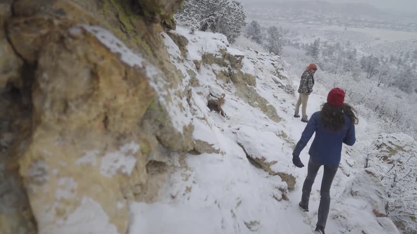 A woman and man out in a forest area covered in snow