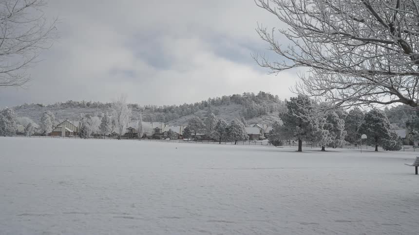 Snow covered rural neighborhood at the foot of mountains on a winter day