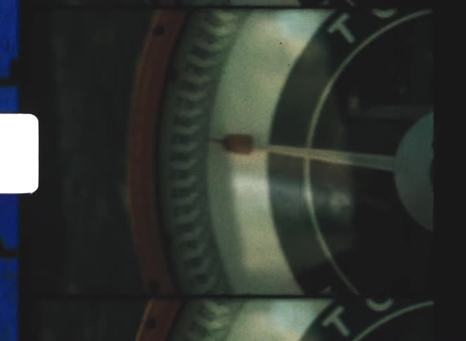 A close up of a large toledo dial scale with a pointer moving outdoors while three people are partially visible nearby