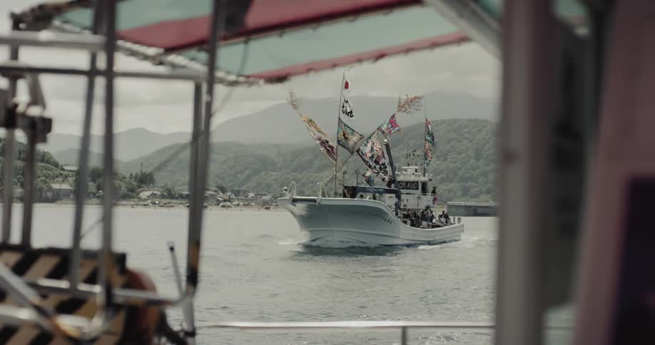Boat with japanese flags sailing on the ocean