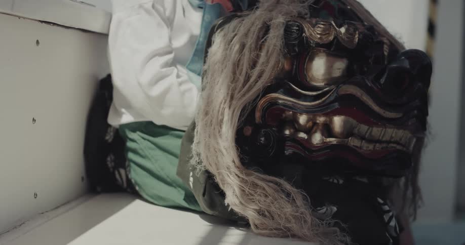 A person holding a mask while sitting