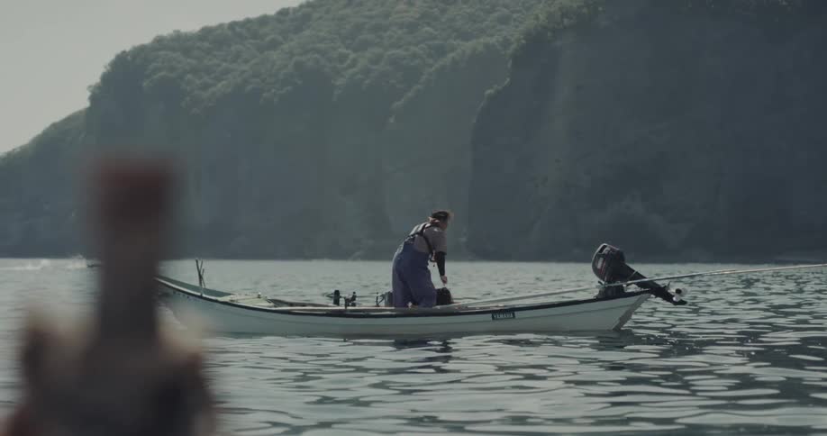 The man lifts a net on his small boat