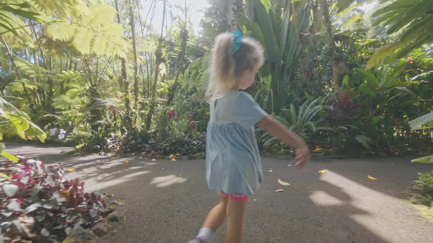 A child running down a trail in a forest