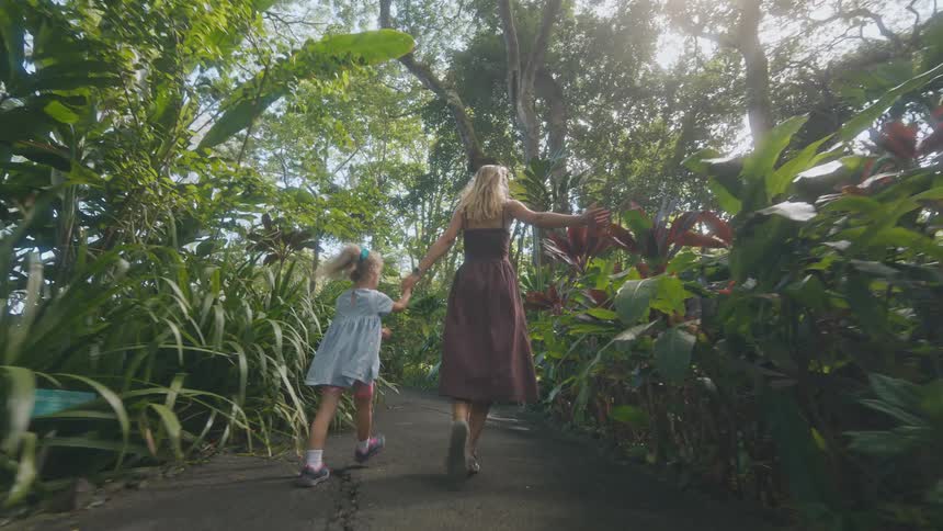 A mother and daughter running through a forest