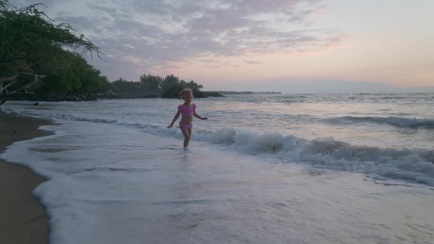 A child playing along the beach