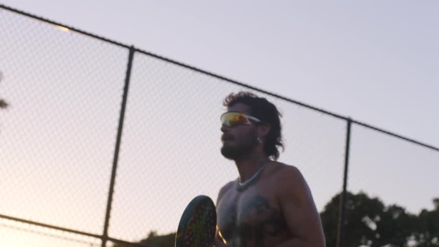 Man plays a racket game at sunset