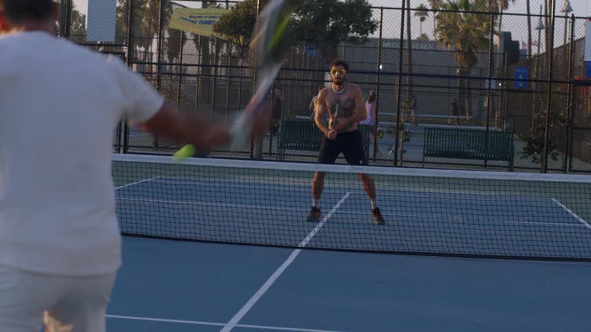 The men are hitting the tennis ball back and forth