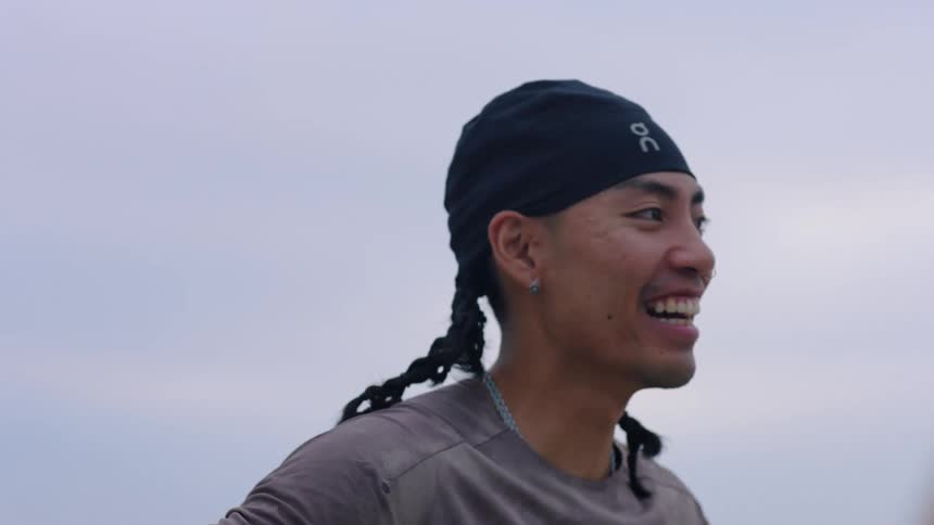 Young adult man wearing a bandanna laughing outdoors