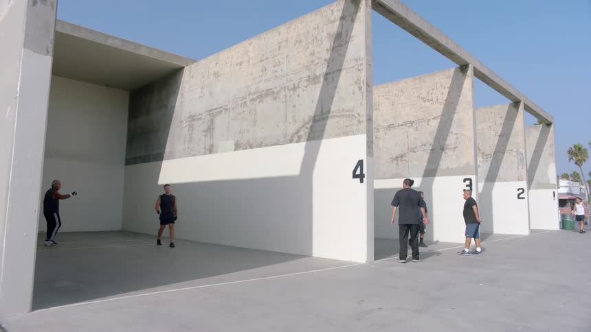 Group of male players playing handball outdoors in a city during daytime