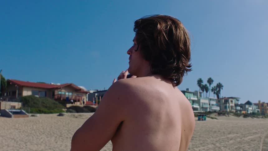 Man on the beach receiving an american football and throwing it