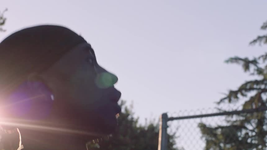 Man in bandana playing basketball outdoors