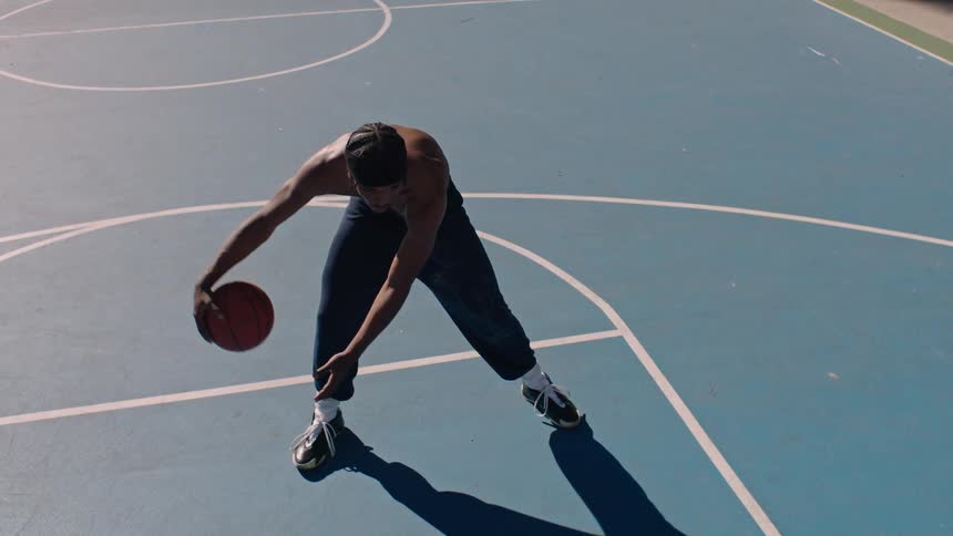 Man playing basketball on an outdoor court