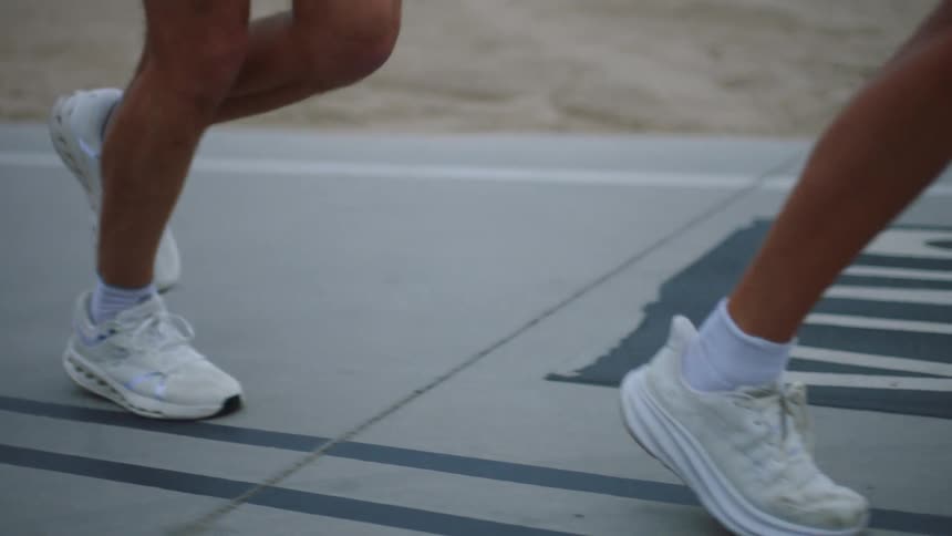 Close up of two people jogging on a road outdoors during daytime