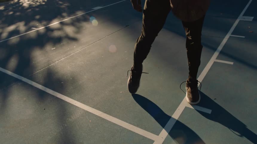 Person dribbling a basketball on an outdoor court