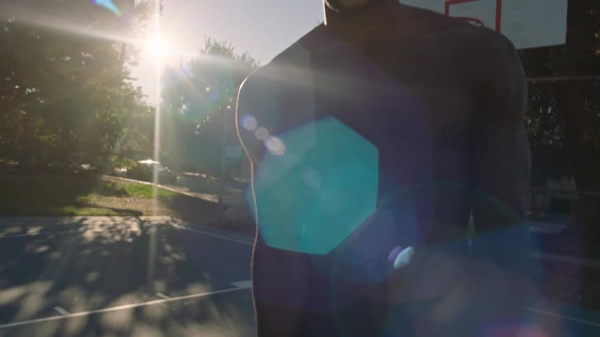 Man playing basketball on an outdoor court