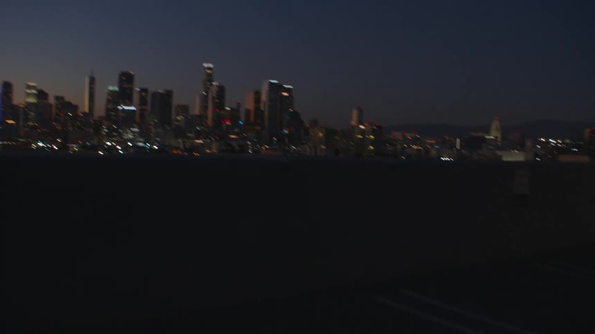 Two young female people running towards a balcony and looking at an metropolitan area outdoors during dusk or dawn