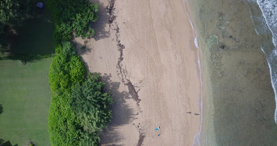 Aerial view looking down at waves rolling over the beach