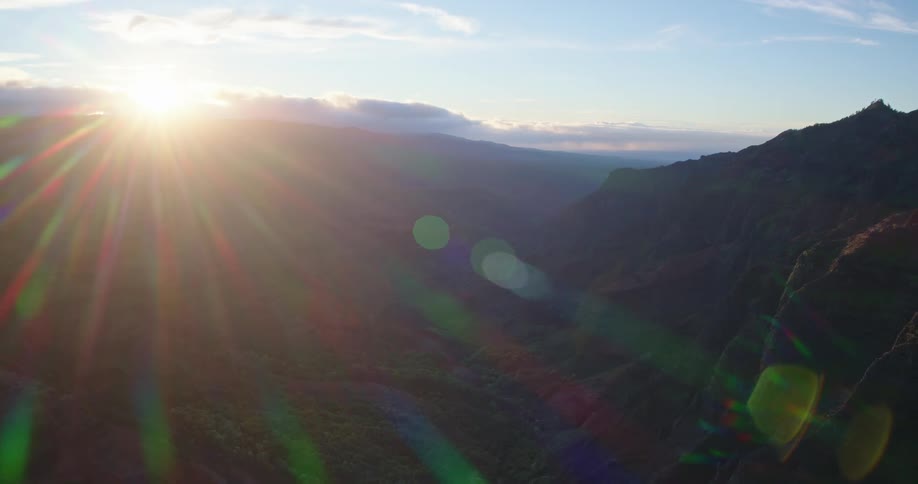 Sunlight shines brightly over mountains in a cloudy sky