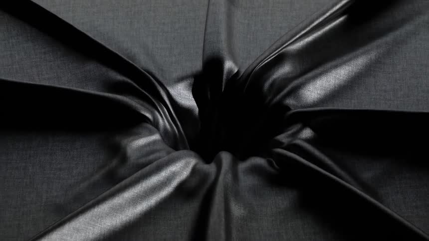 A dark textured fabric is pulled downward into a central hole creating deep radial folds and shadowsas the material is sucked into the void its surface shifts from a matte gray to a glossy silklike black