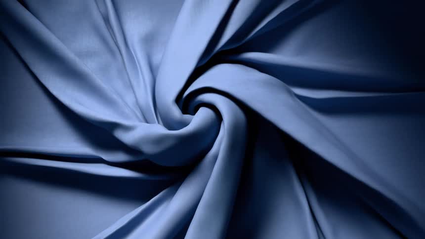 Blue fabric twisted in spiral with soft shadows highlighting texture and depth