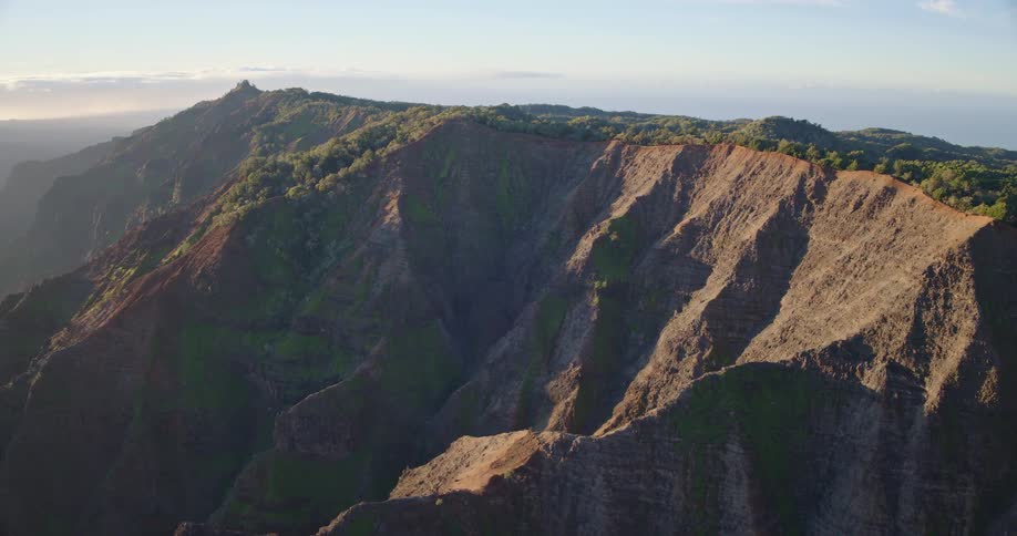 Sunlight shines on the rough terrain of a mountain ridge
