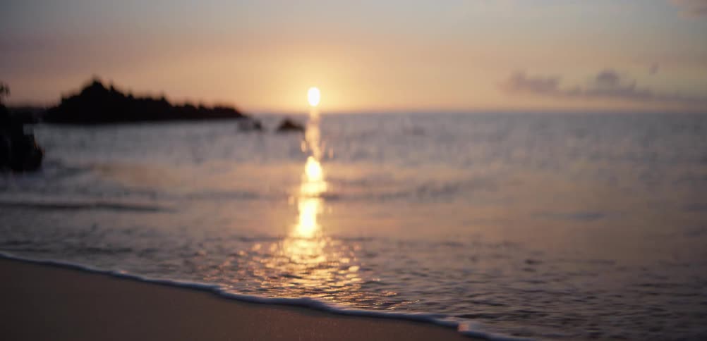 The sun is rising on the beach