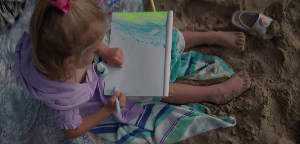 A child coloring on the beach