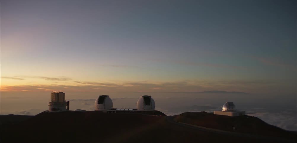 Observatory complex on a mountain summit above the clouds under a twilight sky