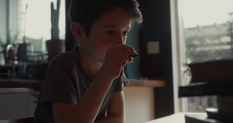 The boy is writing while doing homework
