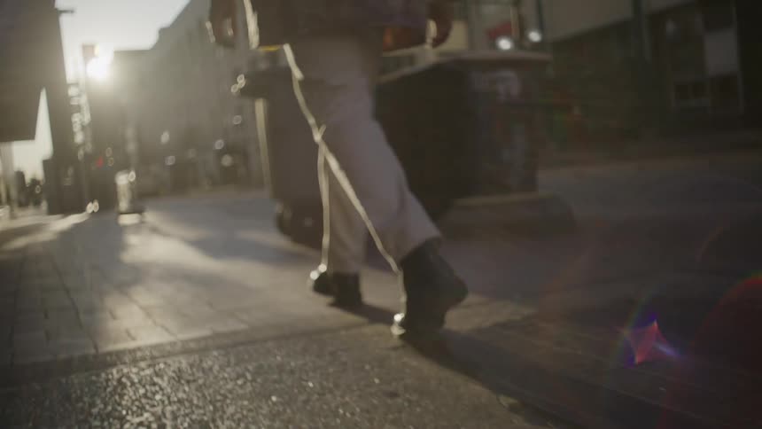 The man is walking on the sidewalk